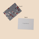 Floral card on front with 'Congratulations!' text on back, on beige background