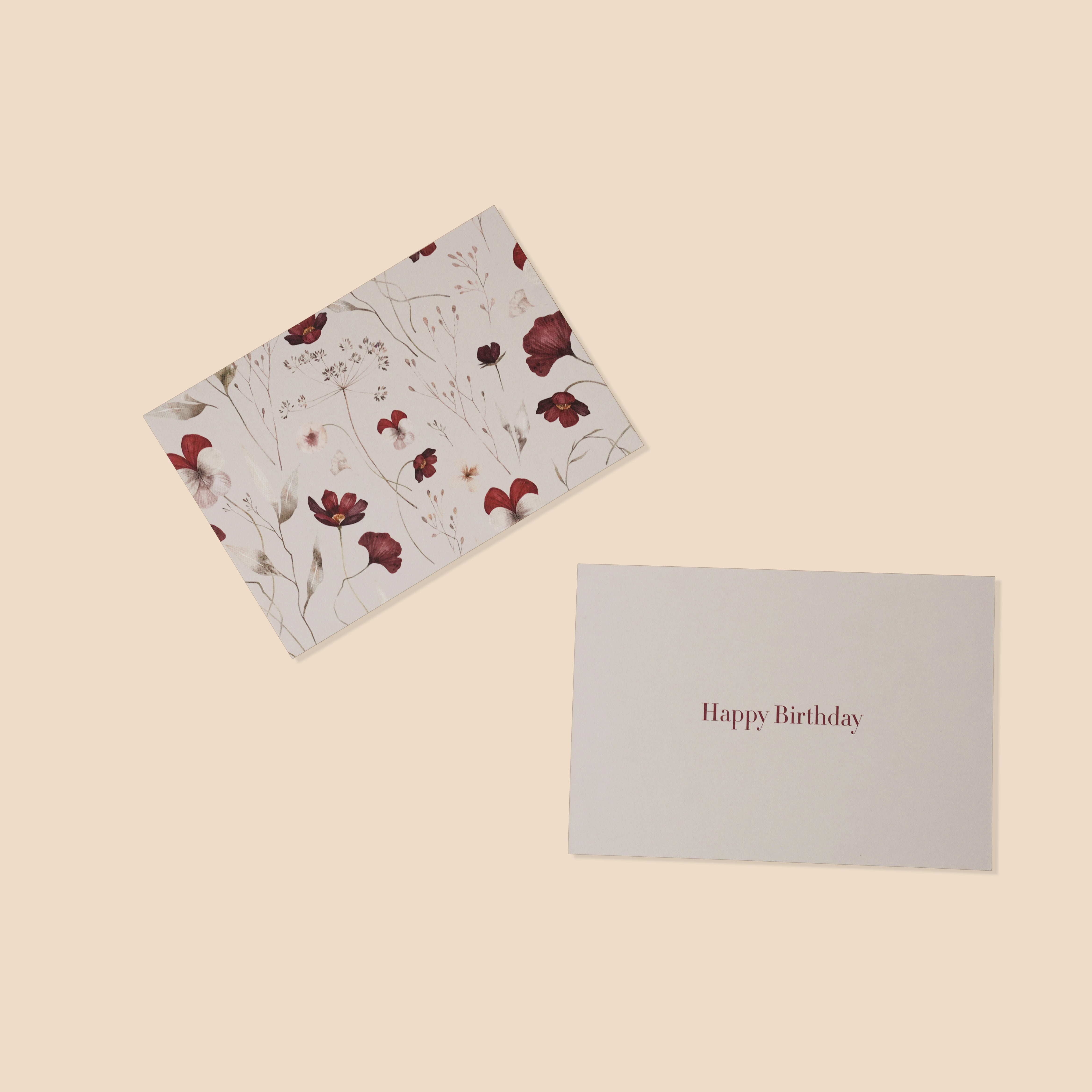 Floral card and 'Happy Birthday' card on a beige background