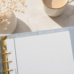Planner with gold binding on a top divider tabs