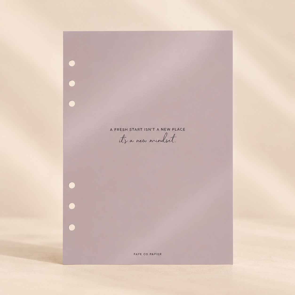 A single sheet of pale lavender paper with three punched holes on the left side and centered text reading, 'A FRESH START (ISN'T A NEW PLACE / it's a new mindset)' with 'FATE CO PAPER' at the bottom planner dashboard